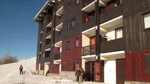 A multi-story building with balconies and a ski slope in the foreground. - Les Menuires, charming renovated two-room apartment at the foot of the slopes    (Les Belleville)