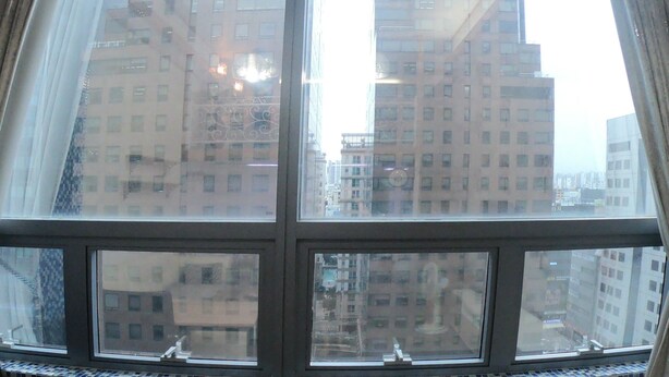 A view through a window with a view of tall buildings. - Gangnam Residence 4 (Seoul)
