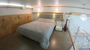 A bedroom with a bed, a nightstand, a decorative vase, and a wooden wardrobe with branch designs. - Gangnam Residence 4 (Seoul)