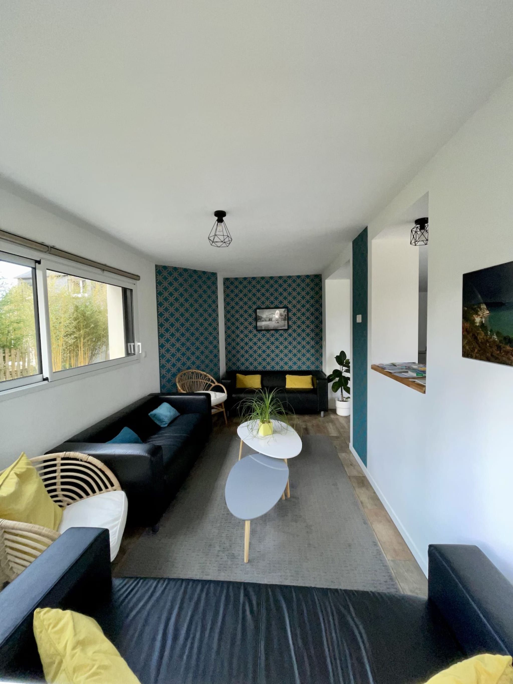 Una sala moderna con un conjunto de sofá, una mesa de centro y una pared con diseño.