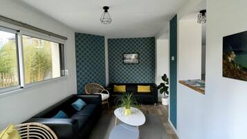 Una sala moderna con un conjunto de sofá, una mesa de centro y una pared con diseño.