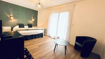 A hotel room with a bed, a desk, a chair, and a small table.
