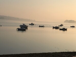 A calm body of water with several boats anchored.