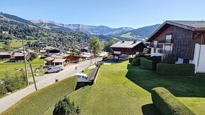 A residential area with houses, a road, and mountains in the background.
