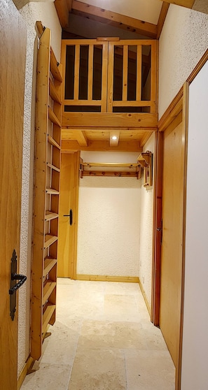 A narrow hallway with a wooden staircase leading to a loft area with a balcony. - Apartment rental near the slopes in the Jaillet area (Megève)