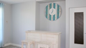 Een kamer met een grote houten dressoir, een klein krukje en een wandklok.