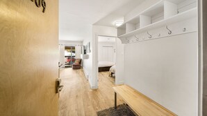 A hallway with a wooden door marked "209", a bench, a coat rack, and a bed in the background. - Newly Renovated, One Bedroom Condominium at Purgatory Steps From Slopes (Durango)