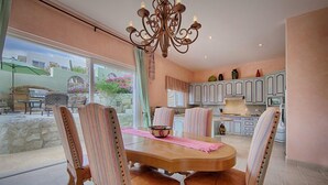 Un coin repas avec une table en bois, des chaises à rayures et un lustre.