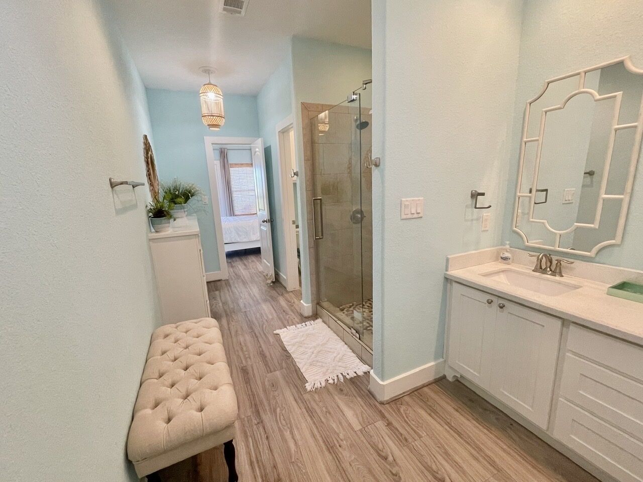 Une salle de bain avec une douche en verre, un meuble-lavabo blanc et un grand miroir.