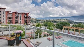 A rooftop pool area with a view of a cityscape and mountains. - Amazing Amenities, Amazing Experiences in West Kelowna!  Pools and more! (West Kelowna)