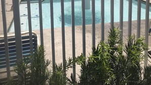 Ein Poolbereich mit mehreren Schwimmbecken, einer pilzförmigen Wasserspielskelett und einem Holzzaun.
