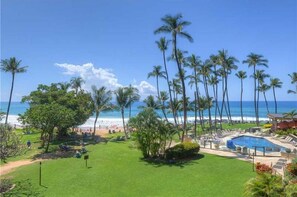 Guests can enjoy ocean views and relax by the pool surrounded by lush greenery.