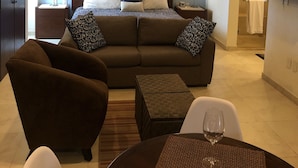 Ein Hotelzimmer mit Bett, Sofa, Couchtisch und Fernseher.
