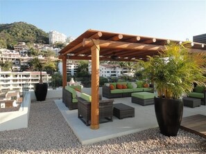 Relax in a shaded patio area with wicker sofas and lush greenery.