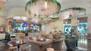 A spacious coffee shop with seating areas, a bar, and a large potted plant. - ☀️Palms 1616-Partial Gulf View🌴Beach Nearby-Lagoon Pool (Destin)