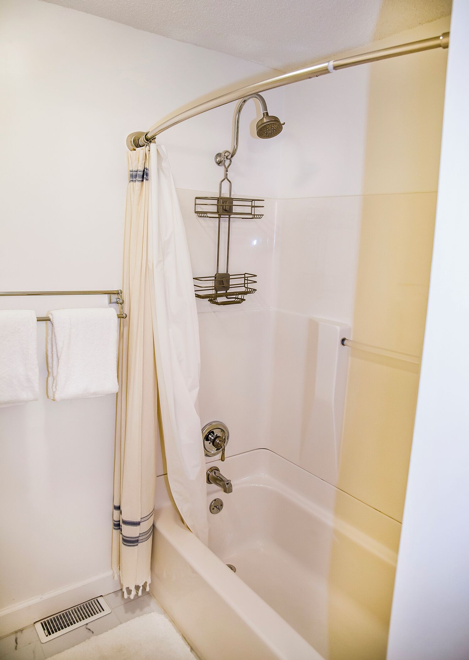 A modern bathroom with a glass-enclosed shower, a bathtub, and a towel rack.