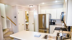 A modern kitchen with a stainless steel refrigerator, a sink, and a countertop.