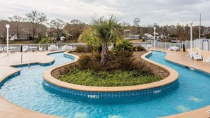 A swimming pool with a palm tree, surrounded by a white fence and lounge chairs. - Harbour Lights™ - 1 Bedroom Deluxe (Myrtle Beach)