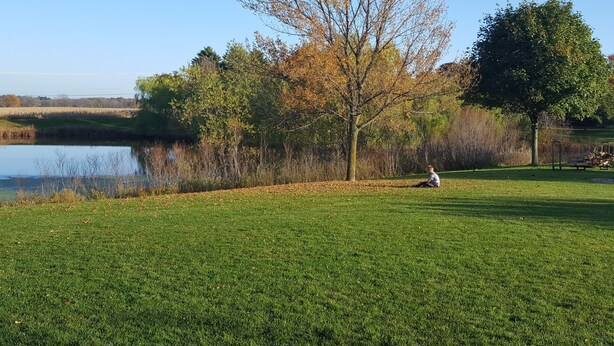 A grassy field with a lake and trees in the background. - 2 bed/2 bath Townhouse on a Quiet cul de sac with backyard views and a Hot tub (Sheboygan)