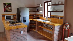 Eine kleine Küche mit Kühlschrank, Mikrowelle und Kaffeemaschine.