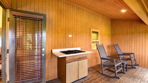A wooden interior with a built-in stove, a window, and two rocking chairs. - Wisconsin Dells | Pool & Waterpark Access | 2BR Timber (Wisonsin Dells)