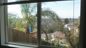 A window with a view of a residential area, including houses and a wooden fence. - ***Romantic View Home Centrally Located in Windsor Hills, La Mesa*** (La Mesa)