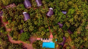 An aerial view of a resort with multiple buildings surrounded by dense palm trees. - Thuduwa Camp (Rankethgama)