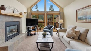 A living room with a fireplace, television, and comfortable seating. - Keystone Townhome Between River Run & Mountain House & Close to Shops/Dining (Keystone)