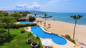 Ein Resort mit einem großen Schwimmbad, einem Strand und Blick auf den Ozean.