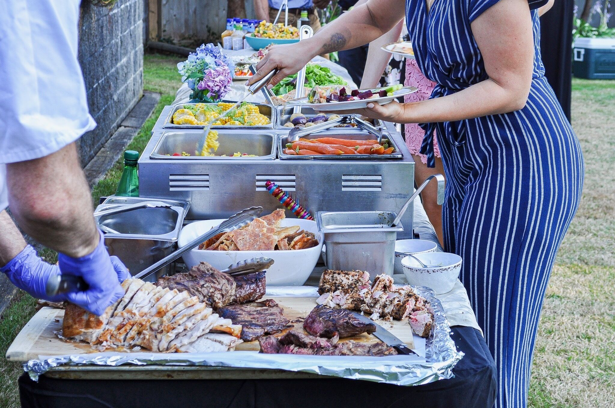 A buffet table with various food items and utensils.
