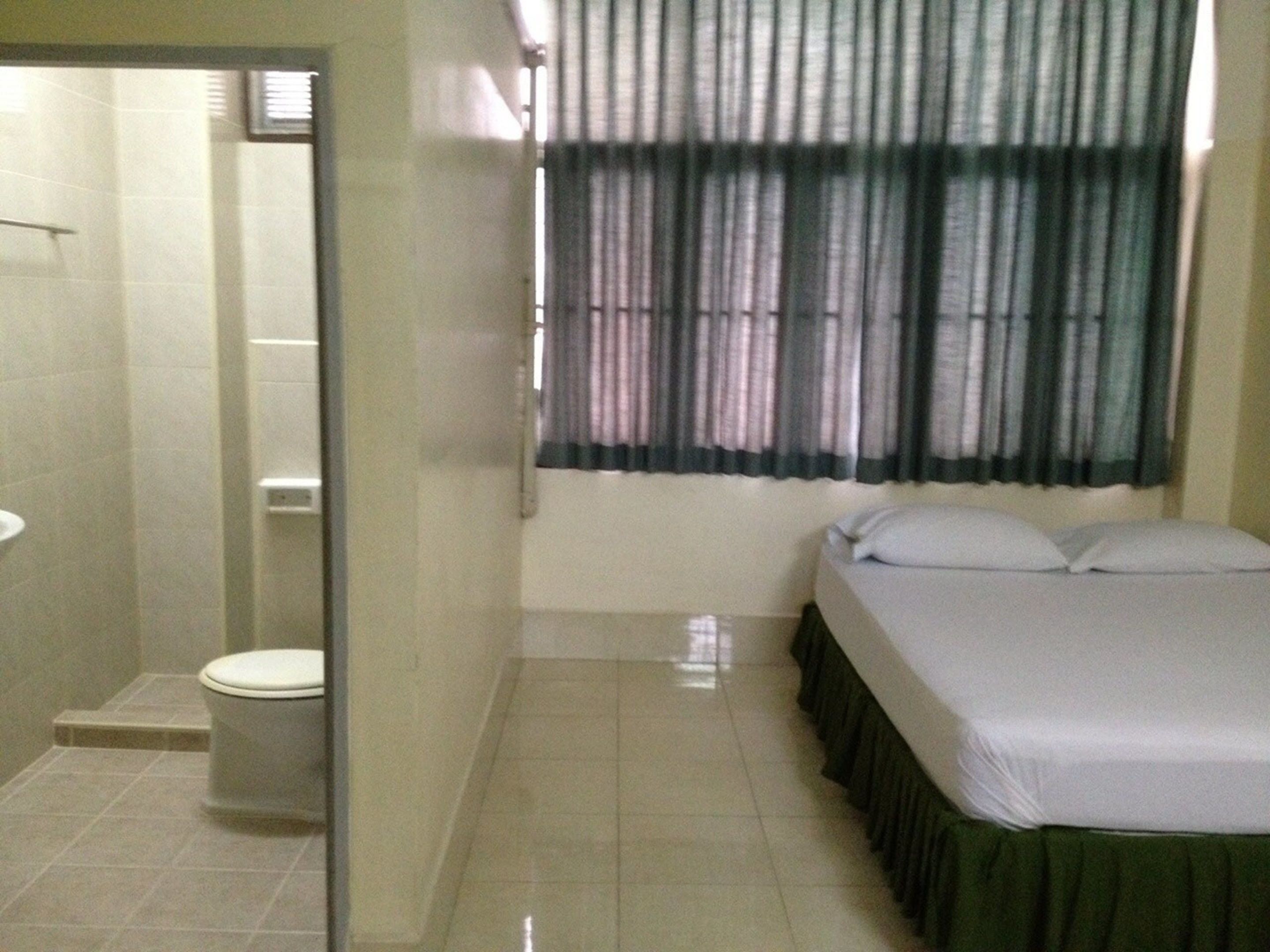 Una habitación con cama, inodoro y ducha.