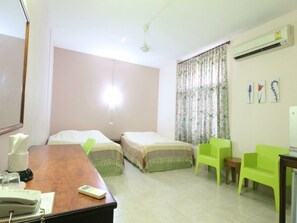 A hotel room with two beds, a desk with a telephone, a chair, and an air conditioning unit. - Numsin Hotel (Ratchaburi)