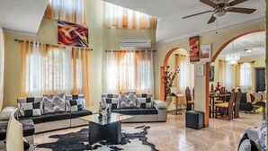 Una sala de estar amplia con un sofá modular, una mesa de centro y una araña.