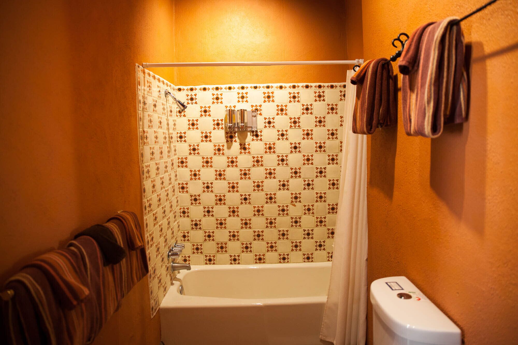 A bathroom with a bathtub, a toilet, and a shower curtain.