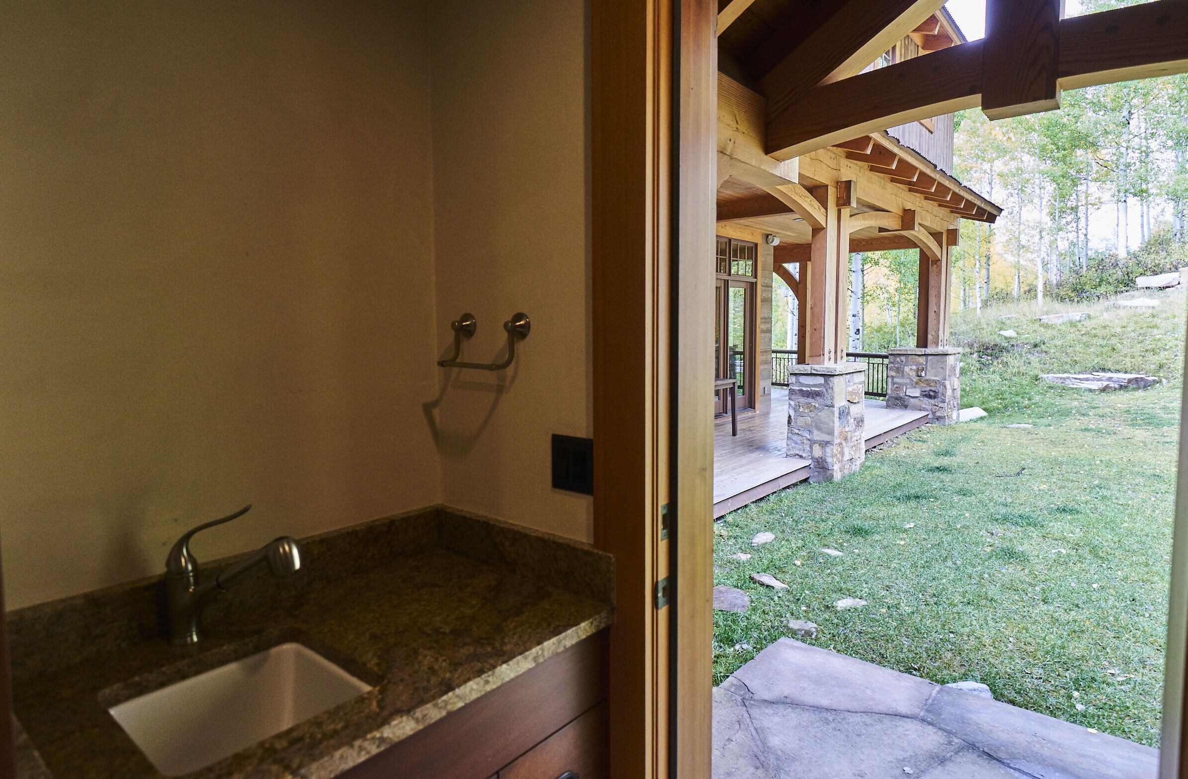 Une salle de bain avec un lavabo en granit et des poutres en bois au plafond.