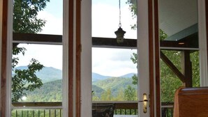 Ein Zimmer mit Blick auf Berge, einem hängenden Laternen und einer hölzernen Bank.