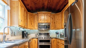 Eine Küche mit Holzausstattung, Edelstahlgeräten und Holzboden.