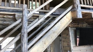 A wooden staircase with a ceiling fan, a TV mounted on the wall, and a window with a view of the outdoors. - 8 miles to Mount Rushmore - Sleeps 2 to 6 (Rapid City)