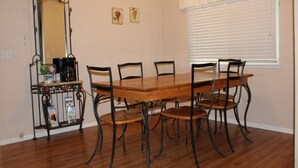 A dining area with a wooden table and chairs, a coffee machine, a mirror, and a window with blinds. - The Decanted Chateau; a two minute drive to Downtown Murphys (Vallecito)