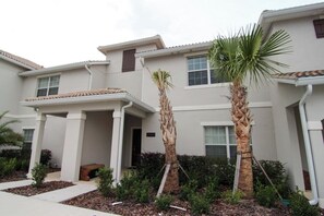 A residential building with a covered porch, palm trees, and a number '3140' sign. - A-Gated Resort-5 miles to Disney-2 FREE Water Park (Osceola County)