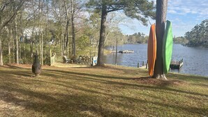 A lakeside park with a deck, chairs, and a rustic vase. - Archie's Lake Daze Cottage - No Pets (Manning)