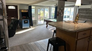 A kitchen with a marble countertop, a small island, and a pool table. - Archie's Lake Daze Cottage - No Pets (Manning)