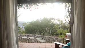 A patio with stone tiles and a view of trees and buildings.
