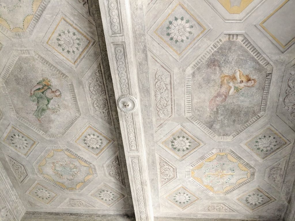 A ceiling with geometric patterns and a central circular design.