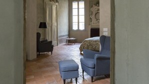 Une pièce spacieuse avec un haut plafond, une cheminée et une grande fenêtre.