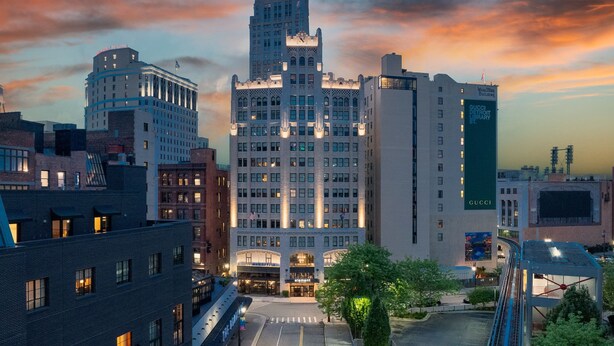 A multi-story hotel with a prominent tower and a modern building with a green facade. - Element by Marriott Detroit at The Metropolitan (Detroit)