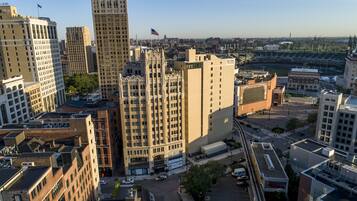 A cityscape with various buildings, including a tall skyscraper and a building with a large sign that reads "Detroit Opera House".