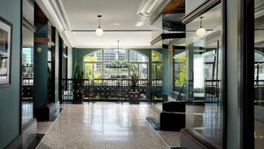 A spacious lobby with a polished floor, large arched windows, and modern lighting fixtures. - Element by Marriott Detroit at The Metropolitan (Detroit)