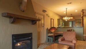 Ein gemütliches Wohnzimmer mit Kamin, Essbereich und Küche.