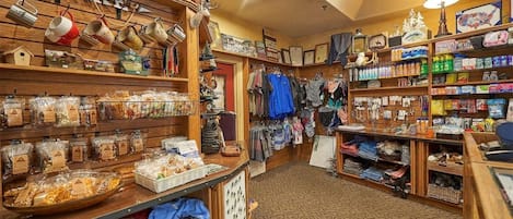 Una tienda con diversos artículos en estantes, incluyendo bolsos, ropa y accesorios.